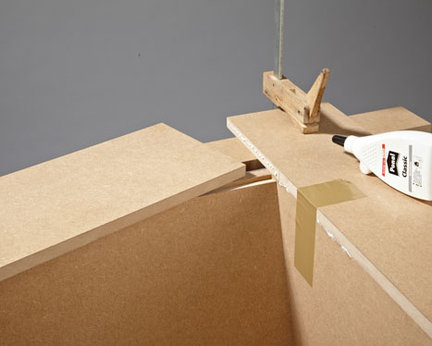 9. Ułożone w podkowę, tworzące jedną płaszczyznę podłokietniki także sklejamy na styk i unieruchamiamy taśmą do klejenia paczek. Podczas gdy klej wiąże, podłokietniki można dodatkowo zabezpieczyć za pomocą drewnianych podpórek.